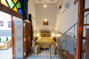 ein Schlafzimmer mit einem Bett in einem Zimmer mit einem Fenster in der Unterkunft Riad Tarab Fes in Fès