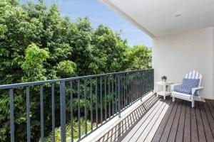 a balcony with a chair and a table and trees at Stylish parkside retreat in Sydney