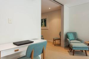 a room with a desk with a laptop and chairs at Stylish parkside retreat in Sydney