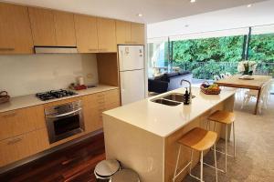 uma cozinha com um lavatório e um fogão forno superior em Stylish parkside retreat em Sydney