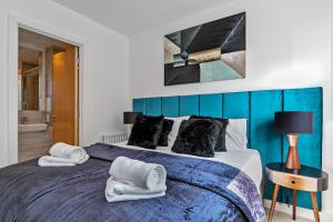 um quarto com uma cama grande e toalhas em LUXURY AIRPORT SUITE, FREE Parking, FANTASTIC Location, Close To Airport, Train Station And Town Centre em Luton