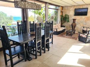 - une salle à manger avec une table et des chaises en bois dans l'établissement Casa en la península de Tongoy, à Tongoy