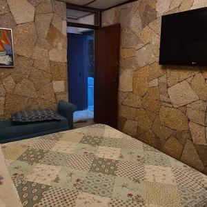 - une chambre avec un lit et une télévision murale dans l'établissement Casa en la península de Tongoy, à Tongoy