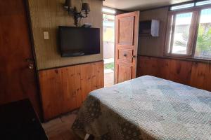a bedroom with a bed and a flat screen tv at Casa en la península de Tongoy in Tongoy