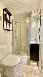 La salle de bains blanche est pourvue d'une douche et de toilettes. dans l'établissement Beautiful 2 bedroom & Free parking, à Turku