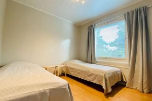 a bedroom with two beds and a large window at Beautiful 2 bedroom & Free parking in Turku