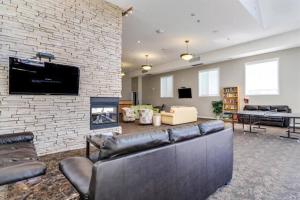 a living room with a couch and a brick wall at Downtown Kelowna 2 Bdrm 2 Bath Waterfront Condo in Kelowna