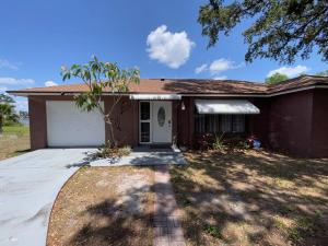 a house with a garage and a tree in front of it at Lakeside retreat - 3 Bedroom, 2 Bathroom house by the lake in Lakeland
