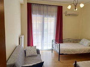 a bedroom with a bed and a couch and a window at Big Apt 3bed 3bath 10 min walk Acropolis in Athens