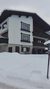 un edificio cubierto de nieve con dos ventanas. en Haus Stofleth en Tschagguns