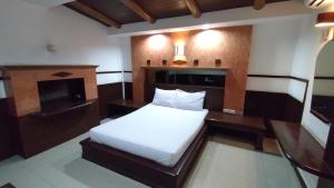 a bedroom with a bed and a desk and a fireplace at MP Inn in Sara Buri