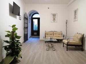 ein Wohnzimmer mit 2 Stühlen, einem Tisch und einer Tür in der Unterkunft Bed And Breakfast Polizzi House in Petralia Sottana