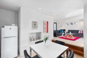 Kangarilla في إميرالد بيتش: مطبخ وغرفة معيشة مع طاولة وكراسي بيضاء