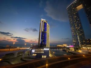 a tall building with blue lights on it at night at Wonderful 1BD With Full Marina View in Dubai