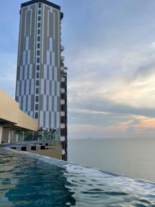 a swimming pool in front of a tall building at Copacabana Pattaya in Jomtien Beach