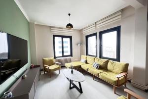 ein Wohnzimmer mit einem gelben Sofa und einem Tisch in der Unterkunft Gorgeous Sea View Apartment in Karaköy 4BR, 2BA in Istanbul