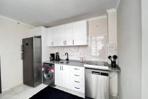 eine weiße Küche mit einem Kühlschrank und einem Geschirrspüler in der Unterkunft Gorgeous Sea View Apartment in Karaköy 4BR, 2BA in Istanbul