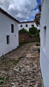 une allée entre deux bâtiments blancs avec une passerelle en pierre dans l'établissement MONTEPERDIDO, à Linares de la Sierra