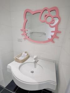 a bathroom with a sink and a pink mirror at 貝兒的家 in Yilan City