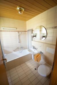 a bathroom with a tub and a sink and a toilet at Haus Kristina in Riezlern