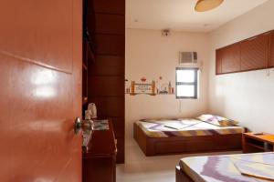 a small room with a bed and a door at TERRA: Grove area, 2 min walk to UPLB Gate in Los Baños