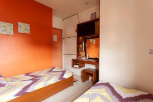a small bedroom with a bed and a sink at TERRA: Grove area, 2 min walk to UPLB Gate in Los Baños