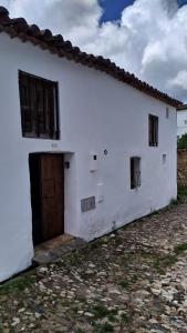 - un bâtiment blanc avec une porte et des fenêtres dans l'établissement MONTEPERDIDO, à Linares de la Sierra