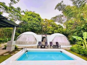 a resort with a swimming pool and two domes at Shanti Wellness Sanctuary in Lemery