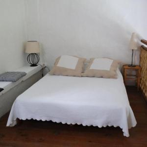 エガリエールにあるMas Grimaud - Gîte- Studio et chambres d'hôtes familialesの白いベッド(枕2つ付)が備わる客室です。