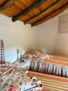 Duas camas num quarto com tectos em madeira em MONTEPERDIDO em Linares de la Sierra