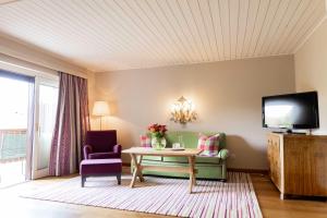ein Wohnzimmer mit einem Tisch und einem TV in der Unterkunft Hotel Gasthof Brandstätter in Salzburg