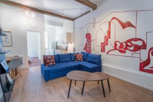 sala de estar con sofá azul y mesa en L'Atelier d'Artiste - refuge bohème et créatif, en Toulon