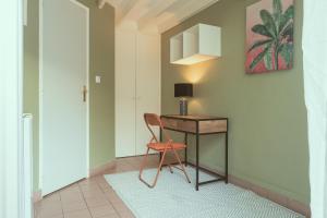 Le Vacoa في لا سالين لو باين: غرفة بها مكتب وكرسي بجوار جدار
