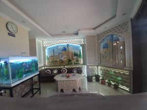 a living room with a large aquarium and a table at The Royal Hotel in Samarkand