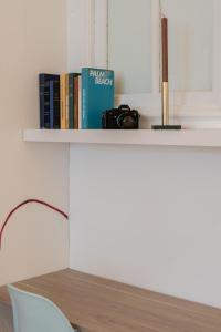 a shelf with a camera and books on it at L'Atelier d'Artiste - refuge bohème et créatif in Toulon