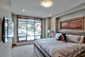 a bedroom with a bed with a teddy bear on it at Village Walk #21 By Bear Country in Sun Peaks