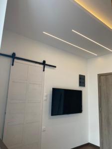 Ein Flachbildfernseher hängt an einer weißen Wand in der Unterkunft Modern Tiny House in Volos in Volos