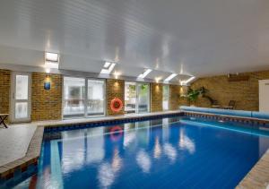 a large swimming pool with a person in the water at La Villa in Rottingdean