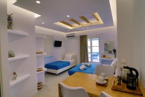 a living room with a blue bed and a table at Coralli Beach Apartments in Mikri Vigla