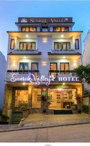 Sunrise Valley Dalat Hotel في دالات: مبنى فيه لافته مكتوب عليها شروق الشمس همسات الفندق