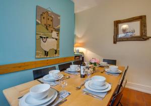 una mesa de madera con platos y platos. en Bryn Hyfryd en Penmaenpool
