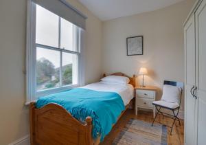 a bedroom with a bed and a window at Bryn Hyfryd in Penmaenpool