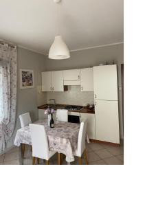 a kitchen with a table and chairs and a kitchen with white cabinets at La Rosa del Garda in Peschiera del Garda