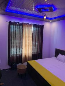a bedroom with a bed and a blue light at Privyrooms in Gorakhpur