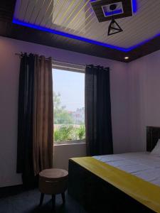 a bedroom with a bed and a window with a tv at Privyrooms in Gorakhpur
