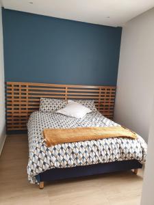 a bedroom with a bed with a blue wall at Luxueux appartement front mer in Sidi Rahal