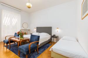 a hotel room with a bed and a table and chairs at Brijuni Rooms Karmen in Fažana