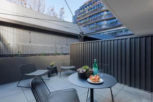 a patio with two chairs and a table with a drink at Veriu Collingwood in Melbourne