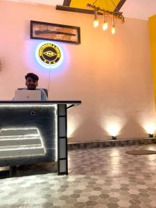 a man sitting at a table with a laptop at Privyrooms in Gorakhpur