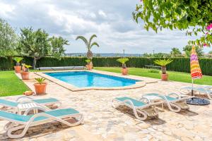 einen Pool mit Liegestühlen und einem Sonnenschirm in der Unterkunft Casa Verde in Sa Pobla
